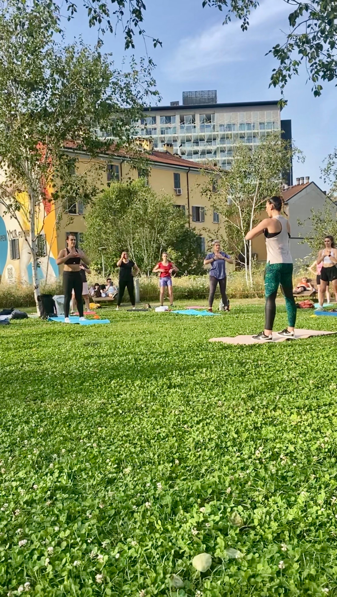 Lezione di gruppo in piedi in un parco cittadino durante una mattina di sole