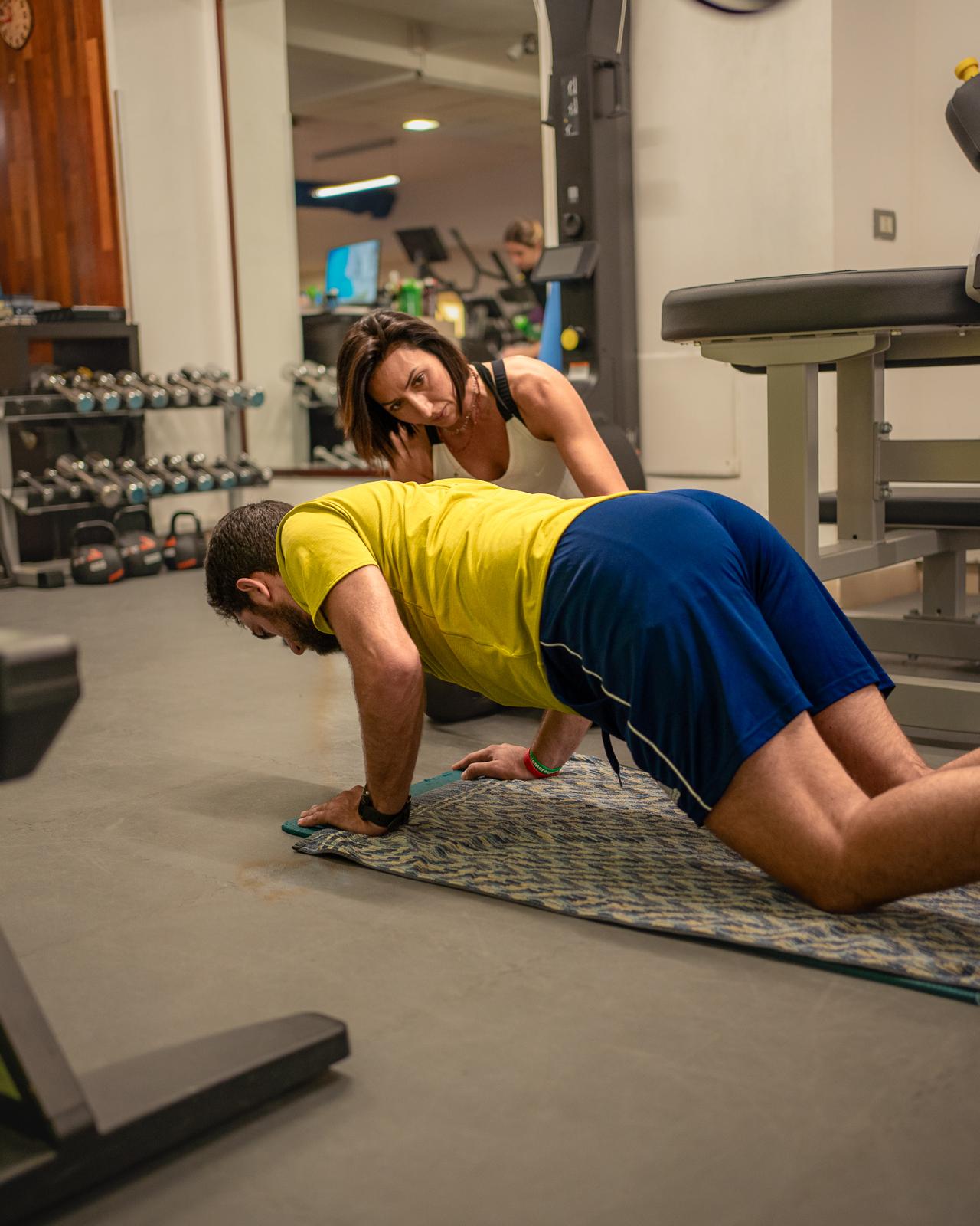 Push-up assistito con supervisione della tecnica durante un allenamento
